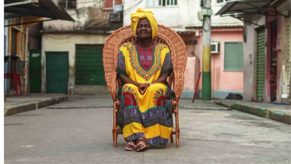Celeste Estrela sentada em uma poltrona no meio de uma das ruas de Manguinhos